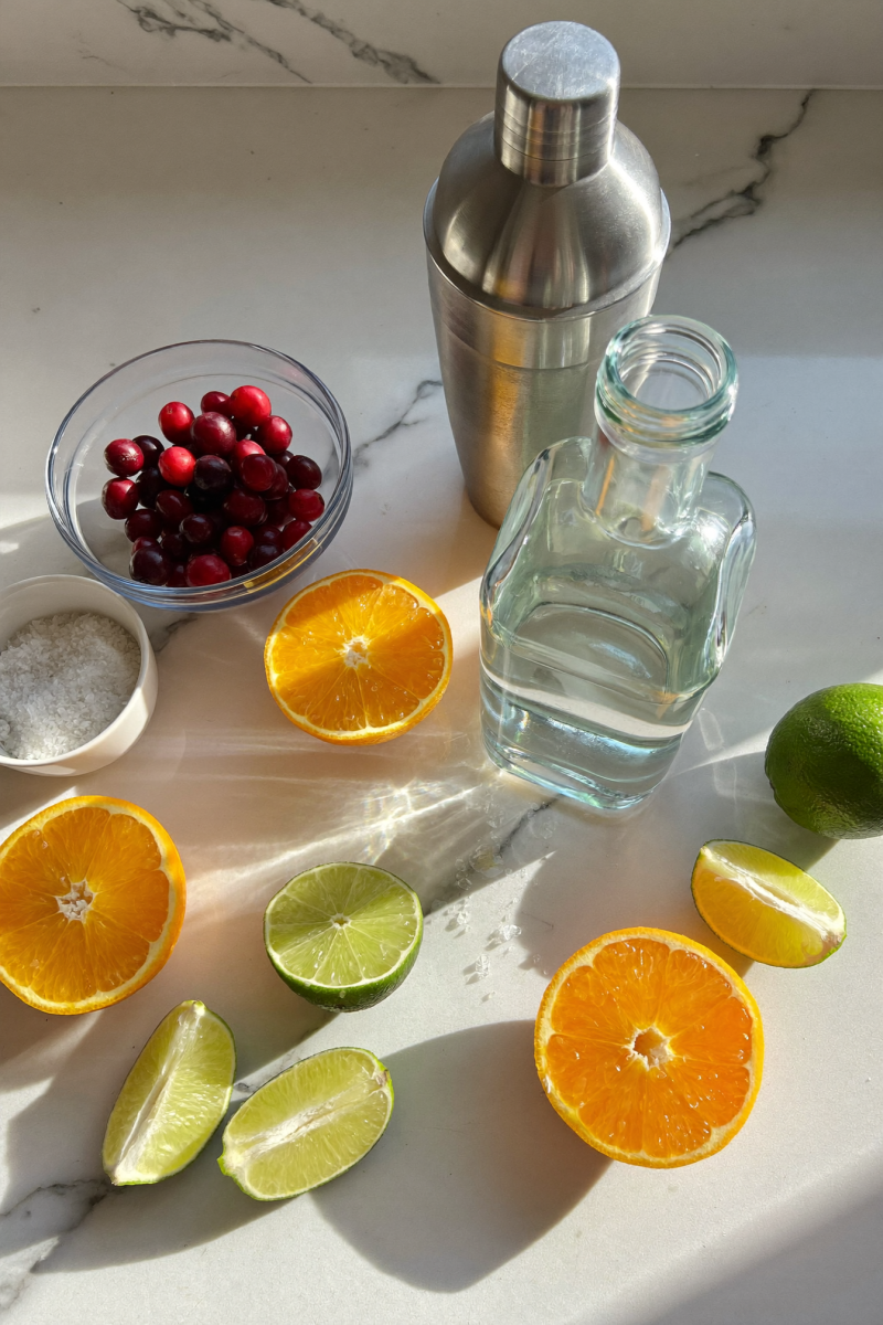 Cranberry orange margarita ingredients on marble counter